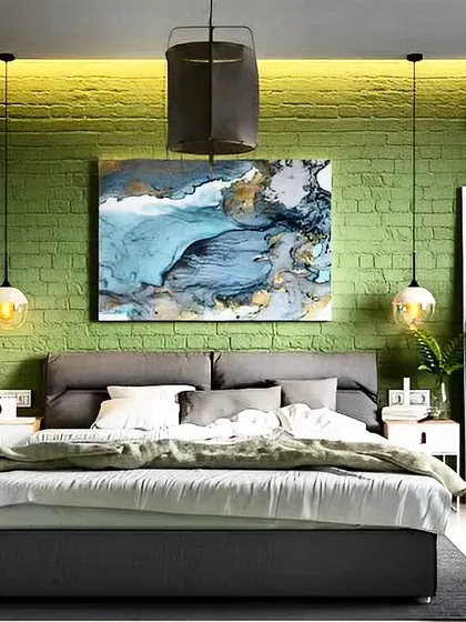 This design uses a textured green brick wall to add character and depth to the bedroom. The abstract art and simple pendant lights complete this modern, industrial-chic look.