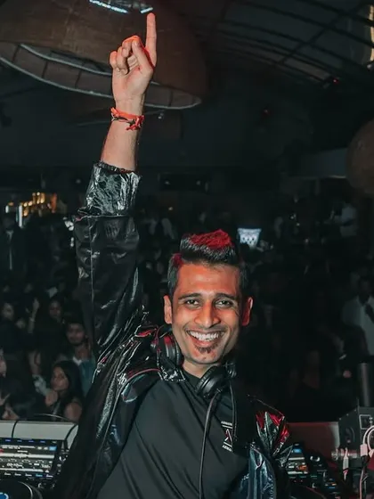 A smile for the camera amidst the chaos. Even when I'm focused on the mix, I always take a moment to connect with the crowd and the photographer.