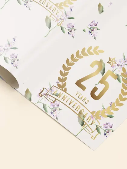 This detailed shot highlights the golden foil accents on the 25th anniversary wrapping paper. It is these small, high quality touches that elevate a design and make it feel truly special.