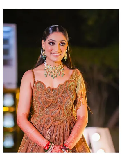 A candid portrait of the bride, her face lit with a happy and genuine smile. The outdoor evening setting with soft lights adds to the warm atmosphere.