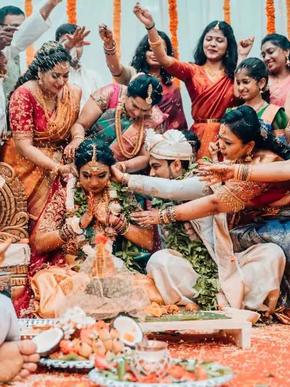 A wide shot capturing the energy and involvement of the entire family during a vibrant South Indian wedding ceremony.