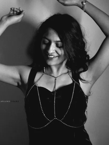 A joyful, expressive moment captured in black and white. The body chain and dance-like pose create a feeling of freedom and movement, perfect for artistic portraiture.