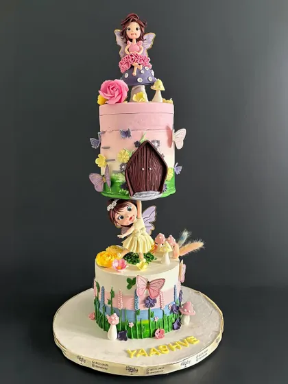 A full shot of the gravity-defying fairy cake, showing the beautiful garden scene on the bottom tier and the floating fairy house on top.