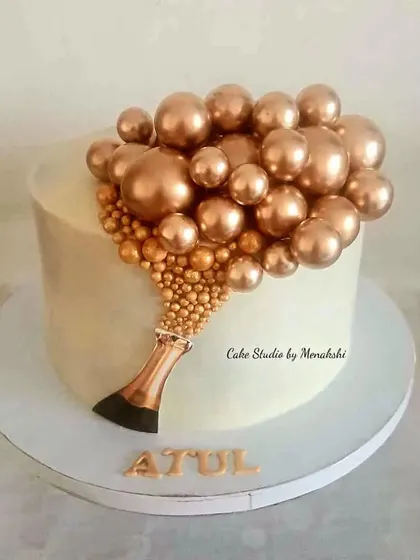 A beautiful celebration cake featuring a champagne bottle pouring out golden bubbles. This elegant design is made without fondant and is perfect for any milestone or achievement.