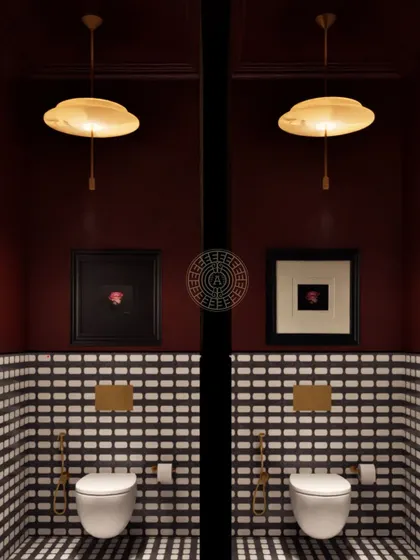 In the ladies' room stalls at Koko, we paired black-and-white patterned tiles with deep crimson walls and artistic touches to make every corner feel special.