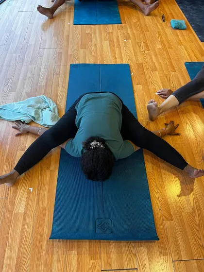 When your body says 'no,' but your yoga teacher says 'just a little deeper!' A moment of surrender in a wide-legged forward fold.