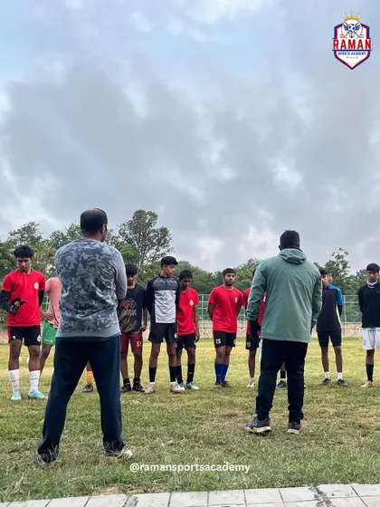 Two coaches discussing strategy with the team during a training huddle. Every session is a step towards becoming champions.