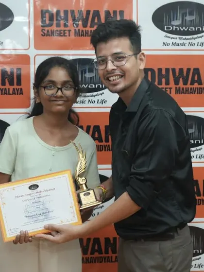 A teacher presents an award to his student.