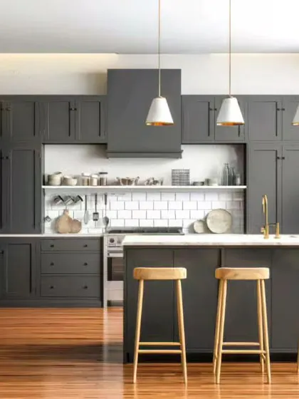 A sophisticated kitchen design featuring dark gray shaker-style cabinets and a white tile backsplash. The central island with pendant lighting creates a perfect spot for meal prep and casual gatherings.