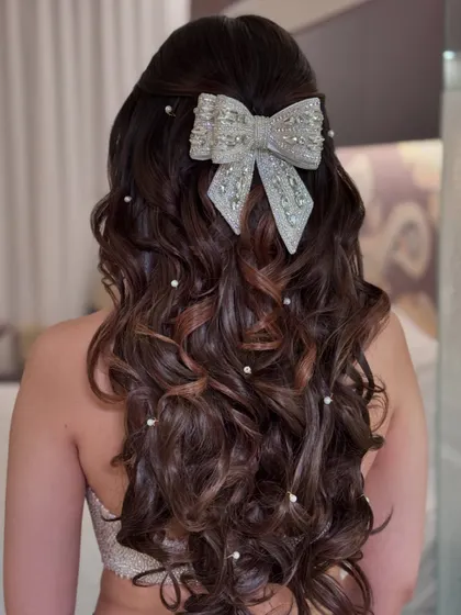 Another angle of the romantic half-up style with a large bow and pearls.