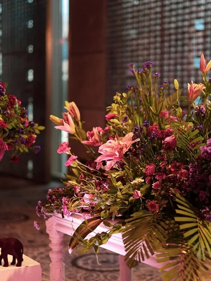 More floral details from the pink-themed event, with small elephant figurines adding a touch of traditional charm.