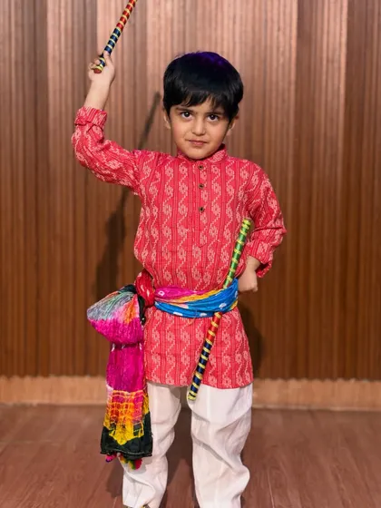 Boys are an integral part of our Garba and Dandiya classes. This young dancer looks sharp and ready in his red kurta and colorful accessories.