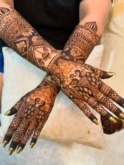 A full view of the peacock-themed design, showing how the motifs are carried up the arms.