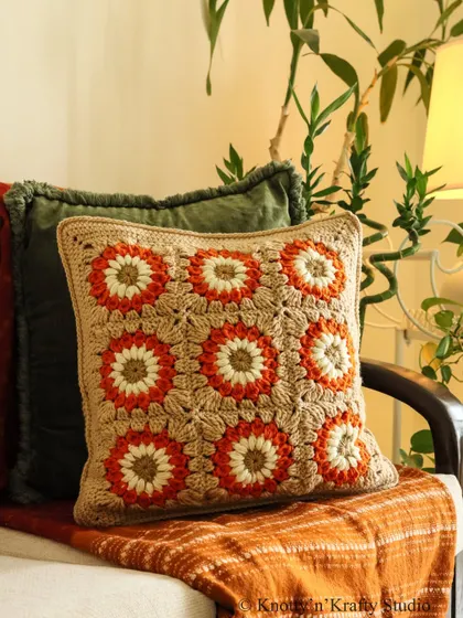 The Sundowner cushion, with its beautiful sun-like floral motifs. The earthy tones are perfect for creating a warm, grounded atmosphere.