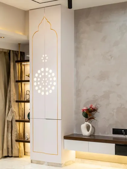 A sacred space where design meets devotion. This bespoke living room mandir features PU shutters with thoughtfully crafted circle cutouts, allowing the space to breathe naturally while maintaining a serene, minimalistic elegance.