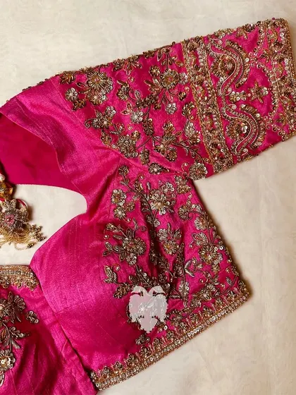 Another angle of the pink blouse, showing the detailed sleeve work.