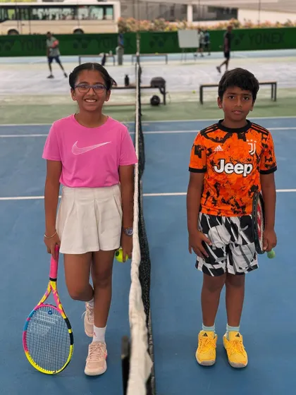 Two junior players ready for their match, showcasing the confidence and readiness we instill. We equip our kids with the right gear and mindset for the game.