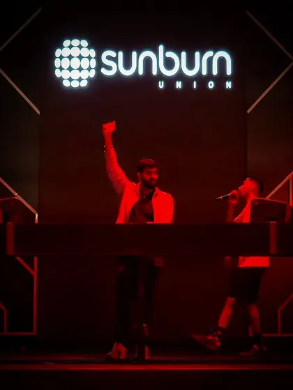 On stage at Sunburn Union for the BMS College fest, fist in the air. I bring the official Sunburn experience to private college events.