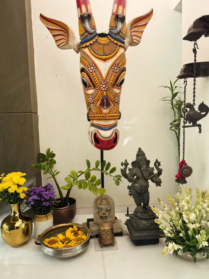 Another view of the decorated corner, highlighting the beautiful blend of traditional art, spiritual idols, and fresh, colorful flowers.