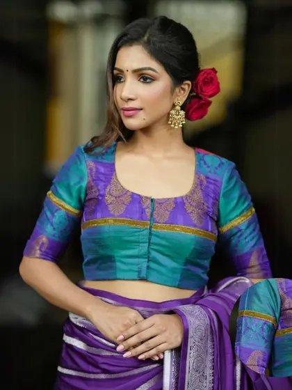 This dual-toned silk blouse in turquoise and purple is a vibrant and unique choice. The front-opening design adds a touch of traditional charm.