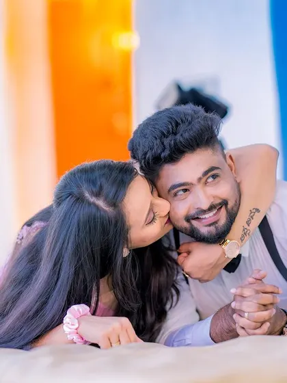 A sweet and playful kiss on the cheek. This close-up shot is full of affection and captures the couple's fun-loving dynamic.