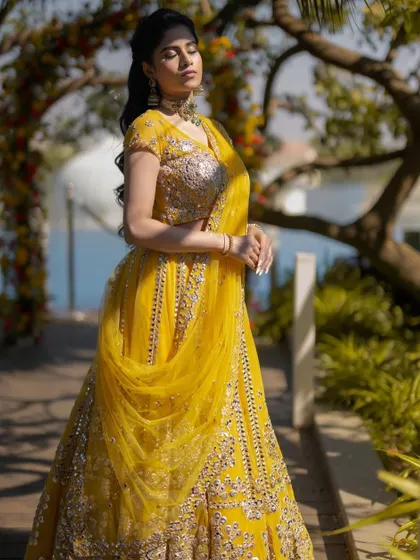A beautiful outdoor shot capturing the flow of the lehenga and the sun-kissed glow of the makeup.