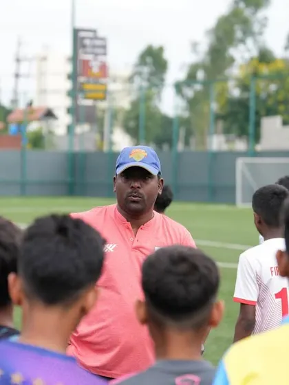 A coach carefully observes players during a trial session. Our experienced scouting team has a keen eye for future stars.