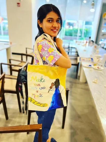 A participant from my tote bag painting workshop proudly displaying her musical-themed creation. These sessions are great for private groups and corporate events.