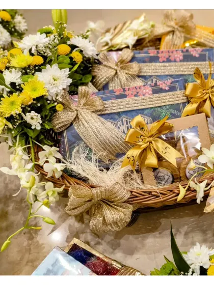A beautifully wrapped hamper from a Roka ceremony collection. The intricate gold bows and fresh floral accents create a look of pure elegance.