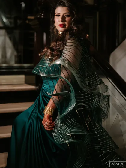 A bride looking absolutely stunning in a modern, structured saree for her reception. We work behind the scenes to ensure our clients can relax and shine on their big day.