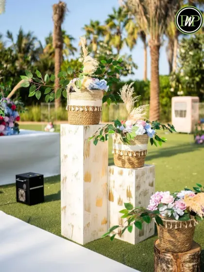 Small details make a big impact. These floral arrangements on modern white pedestals add a touch of elegance to an outdoor wedding walkway.