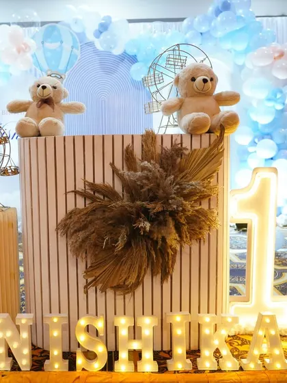 A close-up of a fluted cake table used in a teddy bear themed decor. The combination of the modern table with the soft teddy bears creates a lovely contrast.