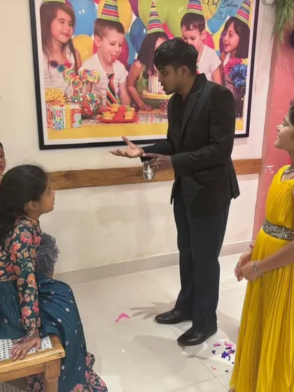 A close up shot of me interacting with two young volunteers at a birthday party. My comedy magic show is all about these fun, unscripted moments with the children.