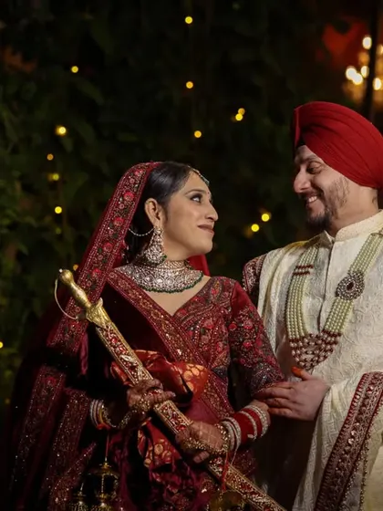 A beautiful portrait of a Sikh couple sharing a happy, loving glance amidst the warm glow of evening lights.