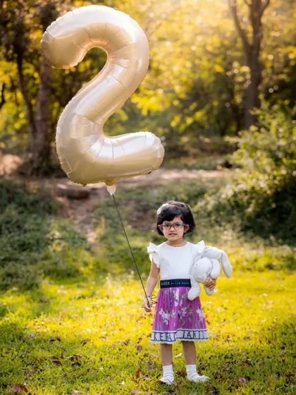 Another angle of this sweet girl turning two in the park. The natural light and open space allow for beautiful, candid moments.