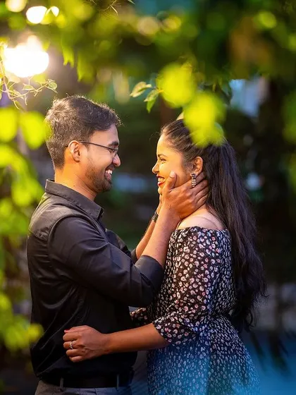 A romantic night shot of a couple sharing a happy moment under glowing lights, showcasing our expertise in low-light photography.