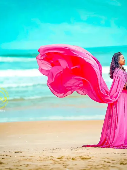 Another angle of the beach photoshoot, showing how the flowing fabric of the gown can be used to create dynamic and romantic images. The makeup was designed to be soft and weather-proof.
