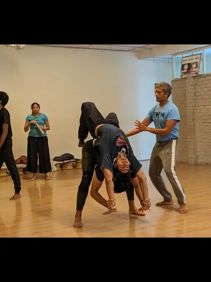 An instructor spots a student during an acrobatic flip, demonstrating our commitment to safety while pushing boundaries.