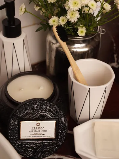 Our Blue Island Water candle in a striking black engraved jar. It's the perfect accessory for a monochromatic bathroom, adding a touch of fresh fragrance and sophisticated style.