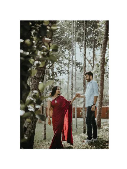 A beautiful portrait of a couple in a forest setting, the tall trees creating a majestic backdrop.