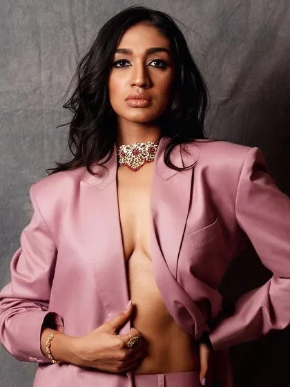 A full-body shot of the pink suit, showing the complete silhouette. The pose is strong and confident, embodying a modern sense of power dressing.