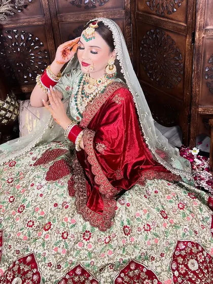 A picture-perfect moment for this beautiful bride. She is wearing a multi-colored lehenga with a contrasting red velvet dupatta, a unique and stunning choice that I helped her customize.