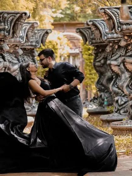 Another angle of the black satin trail gown, showing how it can be used to create dynamic and romantic poses for a pre-wedding shoot.