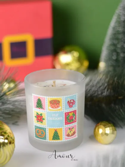 The 'Elf Dreams' jar candle, with a sweet chocolate and vanilla fragrance and a playful, colorful label that looks like postage stamps from the North Pole.