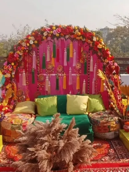 A perfect rooftop Mehandi setup with a vibrant, bohemian vibe. We used a floral arch, colourful tassels, low seating with gaddas, and lots of props for a festive and photogenic event.