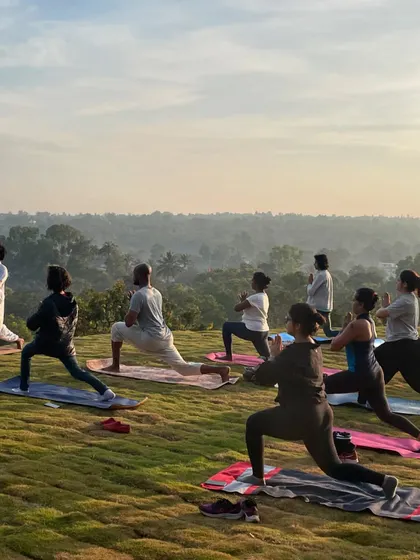 Participants holding a warrior pose (Virabhadrasana) as the morning sun rises. This powerful stance builds confidence and inner strength, qualities that are valuable both on and off the mat.
