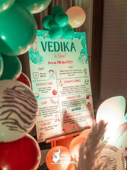 A personalized milestone board for Vedika's first birthday, listing all her favorite things, her 'I can's and 'I love's, designed to match the jungle safari theme.