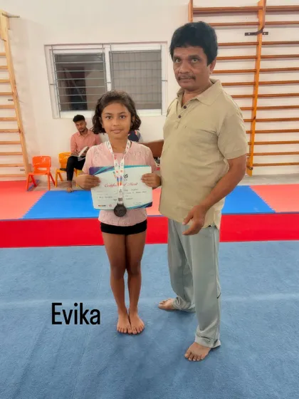 Coach presenting Evika with her medal and certificate. The bond between our coaches and students is key to building confidence and achieving goals.