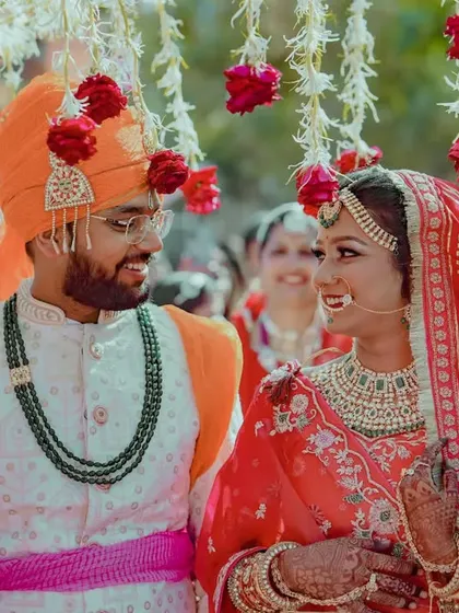 A close-up of the bride and groom under the phoolon ki chadar, capturing their happy smiles and interaction.