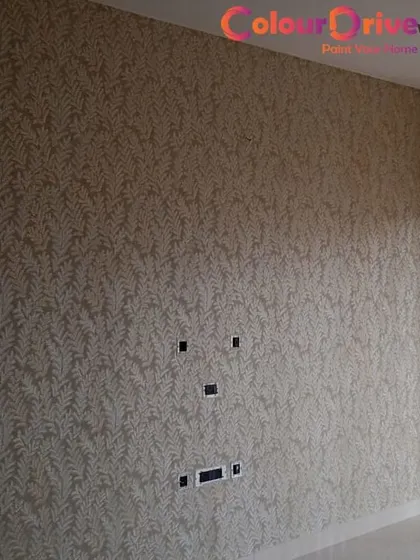 A subtle, leaf-patterned wallpaper applied to a living room wall. This type of textured wallpaper adds depth and a touch of elegance to the space, serving as a sophisticated backdrop for a media unit.
